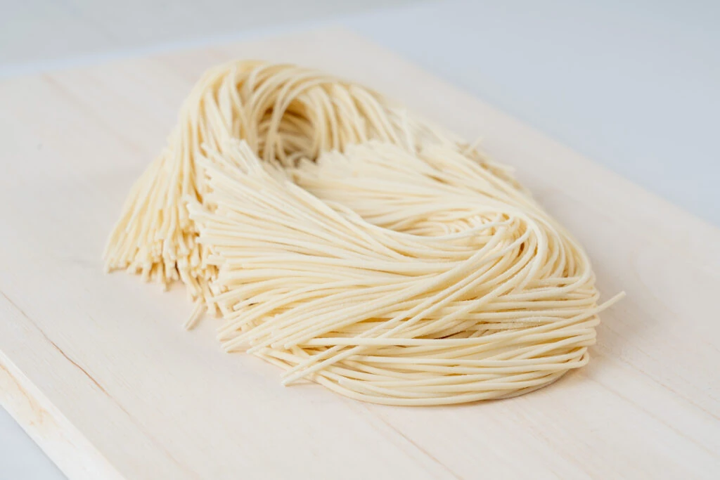 木の板の上にまとめられたマルカツ製麺所の生そうめん(細麺)